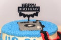 Decorated birthday cake with happy birthday stick pinned close up. Camera-themed round cake for the 31st birthday celebration for