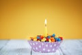 Decorated Birthday cupcake with one lit candle and Royalty Free Stock Photo