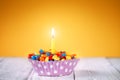 Decorated Birthday cupcake with one lit candle and Royalty Free Stock Photo