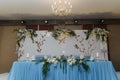 Decorated blue wedding presidium, festive table and arch for just married, event organization. Beautiful flowers and burning