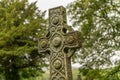 A decorated Celtic cross monument in nature.