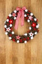 Decorated Christmas Door Wreath Red White Cloth Stars and Gingham Bow on Sapele Wood Background Royalty Free Stock Photo