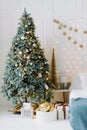 Decorated Christmas room with cozy couch and beautiful fir tree Royalty Free Stock Photo