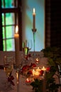 Decorated Christmas table with candles, candlesticks, tealight candles, candle holders, artificial plants, white tablecloth and