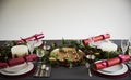 Decorated Christmas table set for four people, with Christmas crackers arranged on plates Royalty Free Stock Photo