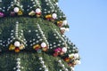 Decorated Christmas tree on the background of blue sky. part of large outdoor Christmas tree closeup