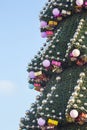 Decorated Christmas tree on the background of blue sky. part of large outdoor Christmas tree closeup