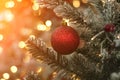 Decorated Christmas tree background. Red ball and illuminated garland with flashlights. New Year baubles macro photo Royalty Free Stock Photo