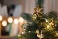 Decorated Christmas tree with big golden star toy on the top against blurred lights on background. Royalty Free Stock Photo