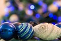 Decorated Christmas tree with blue lights. Christmas balls in the foreground. Blurred image of a Christmas tree in the background Royalty Free Stock Photo