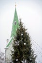 Decorated Christmas tree and church bell tower isolated on sky background, Dobele, Latvia Royalty Free Stock Photo