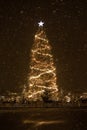 decorated Christmas tree in the city square in a snowstorm, Christmas decorations and garlands Royalty Free Stock Photo