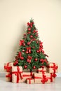 Decorated Christmas tree and gift boxes near wall Royalty Free Stock Photo