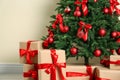 Decorated Christmas tree and gift boxes near wall Royalty Free Stock Photo