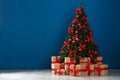 Decorated Christmas tree and gift boxes near wall. Space for text Royalty Free Stock Photo