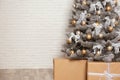 Decorated Christmas tree and gift boxes near brick wall, closeup. Space for text Royalty Free Stock Photo