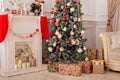 Decorated Christmas tree with gifts, fireplace and candles. Christmas tree decorated with toys, balls and lights glowing garlands Royalty Free Stock Photo