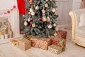 Decorated Christmas tree with gifts, fireplace and candles. Christmas tree decorated with toys, balls and lights glowing garlands Royalty Free Stock Photo