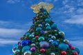 Decorated Christmas tree on lightblue cloudy background at Seaworld.