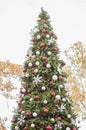 Decorated Christmas tree outside. Tree decorated with red, white and silver ball ornaments, white snowflake ornaments and small Royalty Free Stock Photo