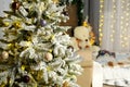 A decorated Christmas tree stands in the background of a children's room decorated with a luminous garland. Royalty Free Stock Photo