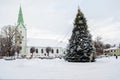 A decorated Christmas tree in a town square with a church in the background, Dobele, Latvia Royalty Free Stock Photo