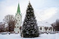 A decorated Christmas tree in a town square with a church in the background, Dobele, Latvia Royalty Free Stock Photo