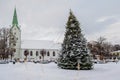 A decorated Christmas tree in a town square with a church in the background, Dobele, Latvia Royalty Free Stock Photo