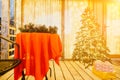 decorated Christmas tree on wooden deck, creating warm ambiance for festive occasion.