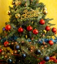 Decorated Christmas tree with written happy holidays in Italian