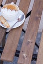 Decorated coffee with cookie and spoon on a wooden table. Close Royalty Free Stock Photo