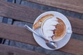 Decorated coffee with cookie and spoon on a wooden table. Close Royalty Free Stock Photo