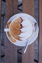 Decorated coffee with cookie and spoon on a wooden table. Close Royalty Free Stock Photo