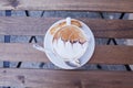 Decorated coffee with cookie and spoon on a wooden table. Close Royalty Free Stock Photo
