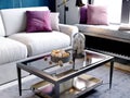 Decorated coffee table next to a white sofa with pink pillows