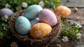 decorated Easter colored eggs with a painted daisy lie in a nest on a wooden table