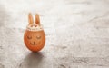 Decorated Easter egg and cute bunny`s ears on gray table Royalty Free Stock Photo