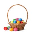 Decorated Easter eggs in wicker basket on white background Royalty Free Stock Photo