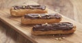 Decorated eclairs with hazelnuts on wood board Royalty Free Stock Photo
