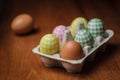 Decorated eggs and brown hen egg in cardboard box Royalty Free Stock Photo