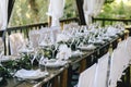 Decorated elegant wooden table for a wedding feast in the gazebo in the rustic style with eucalyptus and flowers, porcelain plates Royalty Free Stock Photo