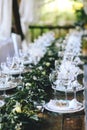 Decorated elegant wooden wedding table in rustic style with eucalyptus and flowers, porcelain plates and glasses Royalty Free Stock Photo