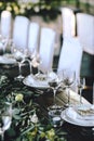 Decorated elegant wooden wedding table in rustic style with eucalyptus and flowers, porcelain plates and glasses Royalty Free Stock Photo