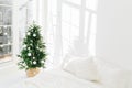 Decorated festive Christmas tree in white classic bedroom interior with soft bed. Winter home interior. Cozy season. New Year, Royalty Free Stock Photo