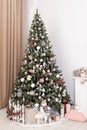 Decorated fir tree and gift boxes near fireplace in living room Royalty Free Stock Photo