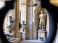 Statues seen from an iron grate window of Palace Mattei of Jupiter to Rome in Italy.