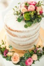 Decorated by flowers white naked cake, rustic style for weddings, birthdays and events. Royalty Free Stock Photo