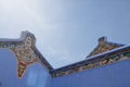 Decorated gable ends with of an eclectic chinese building with blue lime wash walls Royalty Free Stock Photo