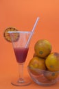 Decorated glass of a cocktail with blood oranges juice next to a bowl with blood oranges Royalty Free Stock Photo