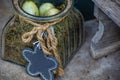 Decorated glass with three green little bird eggs on green dry moss. Blackboard on a cord as flower shape for text Royalty Free Stock Photo